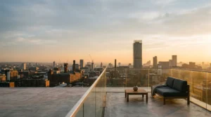 Luxury duplex penthouse terrace overlooking Manchester city skyline at golden hour