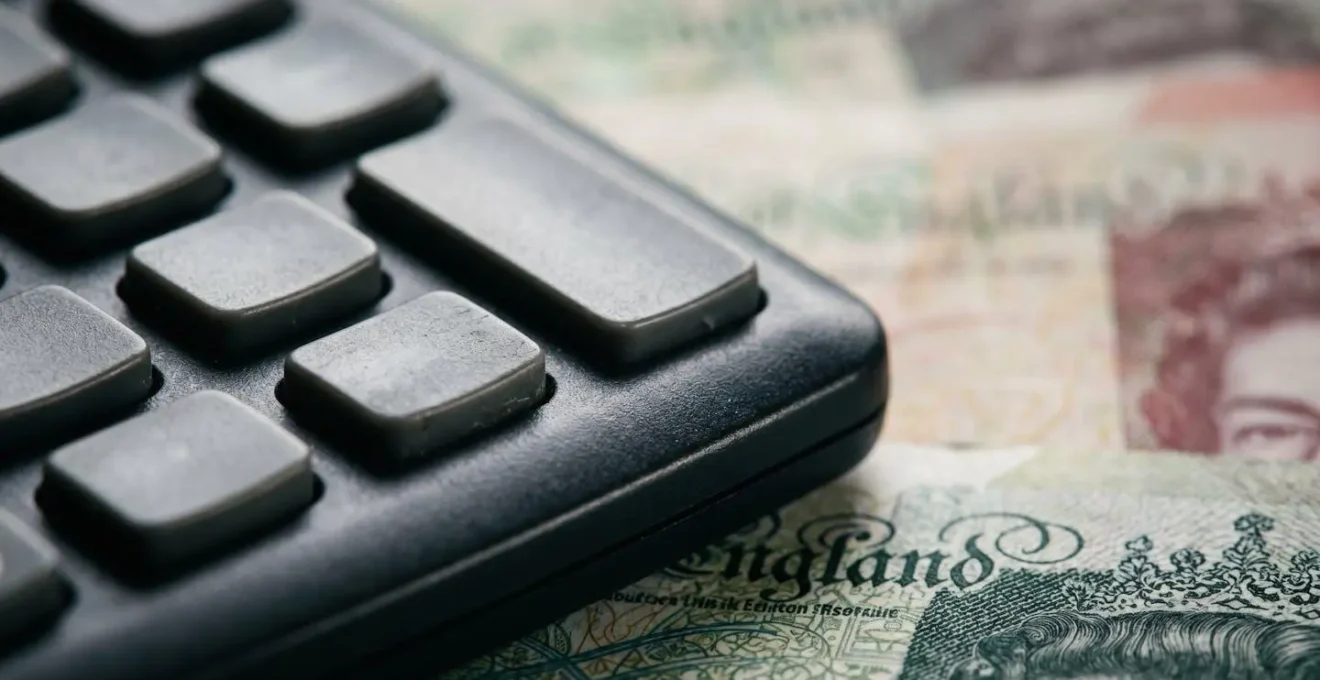 Extreme macro detail of financial calculator keys and currency texture showing penalty interest calculation with shallow depth of field
