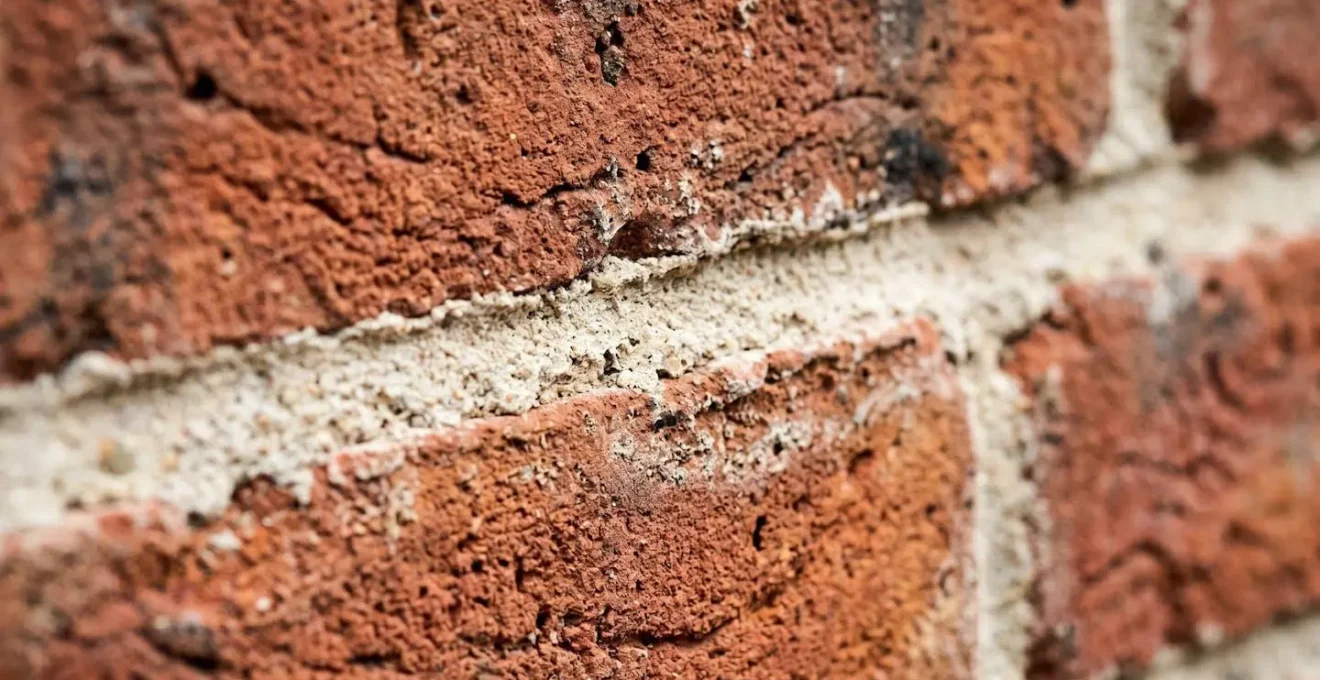 Extreme close-up macro photograph of Victorian red brick texture showing weathered mortar and period craftsmanship detail