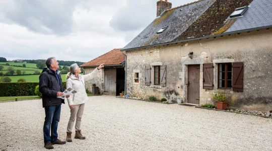 A British couple inspecting a traditional stone farmhouse for sale in the Limousin countryside.
